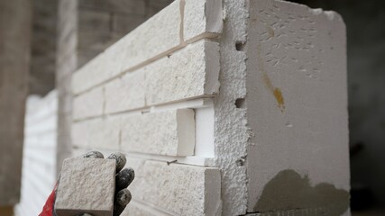 White exterior wall tiles mounted on polystyrene foam. Decorative tiles on the facade of the house.