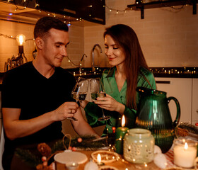 Young couple on a romantic date celebrating christmas, valentine's day and drinking sparkling wine