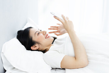Obraz na płótnie Canvas image of girl using phone in bed, in the morning