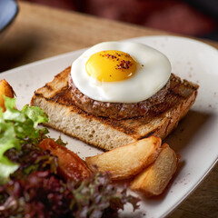 scrambled eggs with steak - classic English breakfast with egg and potato wedges