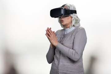 Old caucasian woman wearing virtual reality goggles.