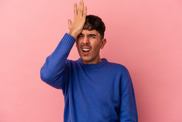 Young mixed race man isolated on pink background forgetting something, slapping forehead with palm...