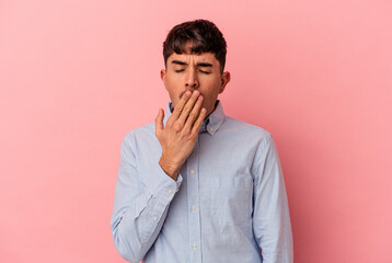 Young mixed race man isolated on pink background yawning showing a tired gesture covering mouth with hand.