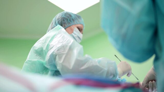 woman surgeon is performing operation in surgery