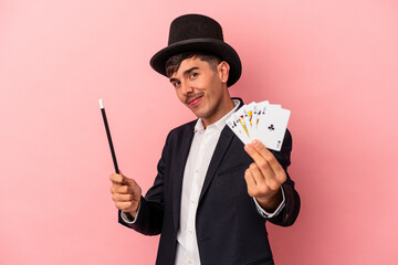 Young caucasian wizard man holding a magic cards and wand isolated on white background