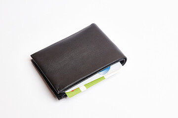 Several plastic payment cards look out of a black leather wallet.