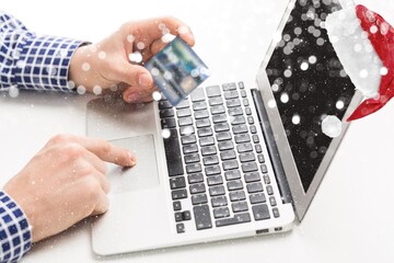 A woman orders gifts over the Internet. A hand holds a credit card. Online ordering. Online shopping