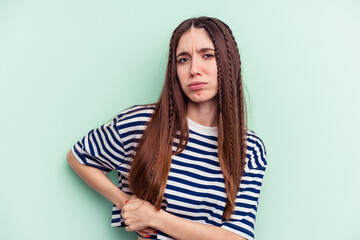 Young caucasian woman isolated on green background having a liver pain, stomach ache.