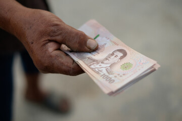 Thailand banknote money holded by senior farmer hand
