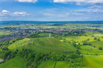 Fototapeta na wymiar Glastonbury tor filmed from drone on sunny day, footage was taken from dji mavic pro 2 drone, iconic monument in the middle of the countryside