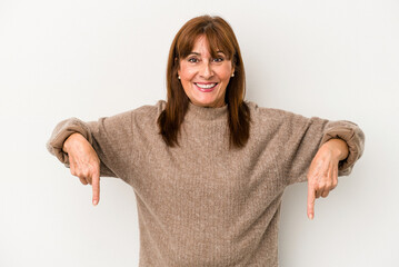 Middle age caucasian woman isolated on white background points down with fingers, positive feeling.