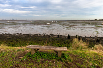 Bench overlooking the River Medway Estuary at Low Tide at Upchurch in Kent, England