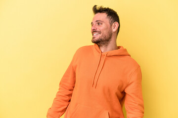 Fototapeta premium Young caucasian man isolated on yellow background relaxed and happy laughing, neck stretched showing teeth.