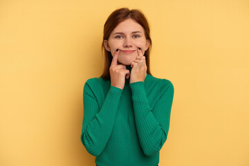 Young English woman isolated on yellow background doubting between two options.