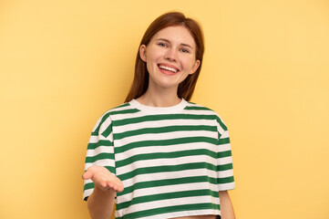 Obraz premium Young English woman isolated on yellow background stretching hand at camera in greeting gesture.