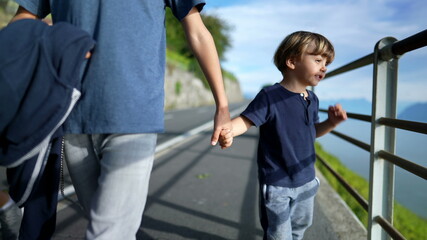 Tow children holding hands, brother holding little sibling hand