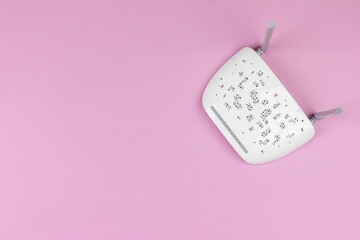 new white Wi-Fi router with gray antennas on a pink background top view from a copy space
