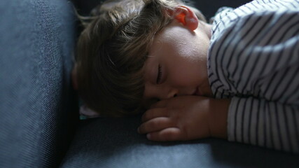 Fototapeta na wymiar Toddler asleep on sofa. Child napping on couch