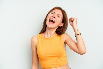 Young English woman isolated on blue background celebrating a victory, passion and enthusiasm, happy expression.