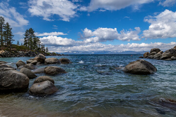 Lake Tahoe with rocks under the bright sky with clouds in Stateline, Nevada, USA