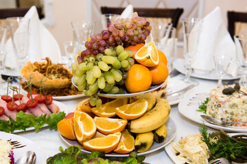 Fruits on the festive table. A table with food served with dishes for guests.