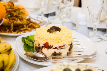 New Year's salad Olivier on the festive table. A table with food served with dishes for guests.
