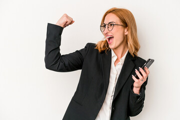 Young business caucasian woman holding mobile phone isolated on white background raising fist after a victory, winner concept.