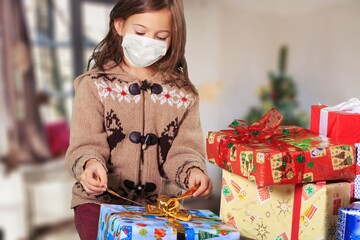 Easy to buy with online shopping! Satisfied girl with medical mask holding Christmas present,