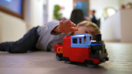 Child playing with toy on hardwood floor. kid plays at home