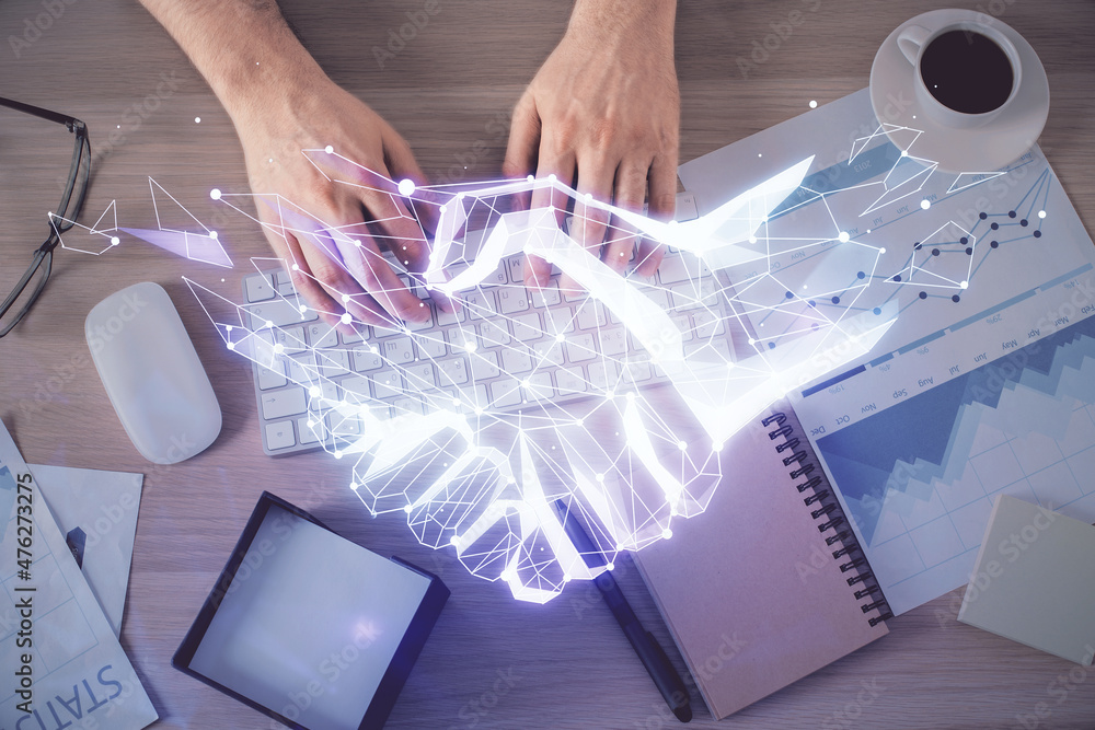 Poster double exposure of man's hands typing over computer keyboard and handshake drawing. top view. partne