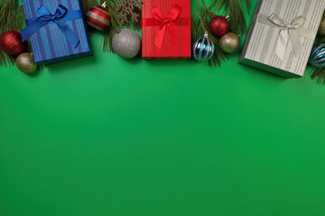 Studio Photo of Colorful Christmas Presents, ornaments, and real pine boughs on a festive green background