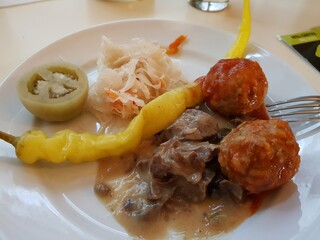 A dish with meat meatballs and pickles