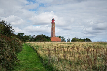 Flugge lighthouse at the Fehmarn island against a blue cloudy sky on a gloomy day