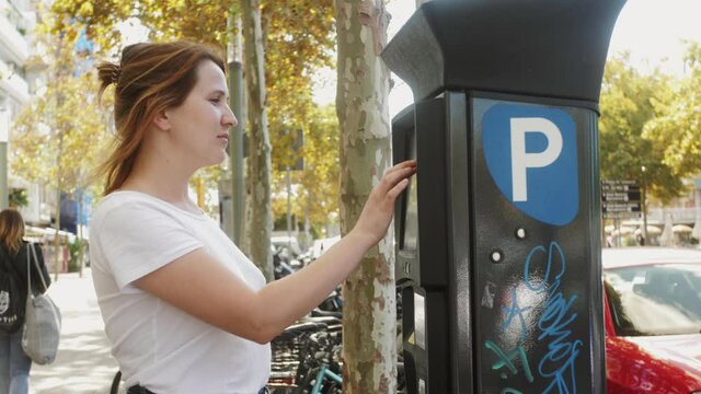 Close-up of parking meter. Woman paying for the parking at the teller parking ticket payment machine.