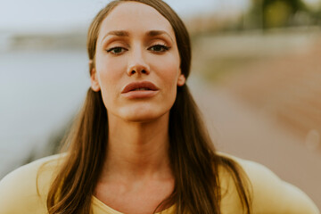 Young woman having stretching exercise on the riverside pier