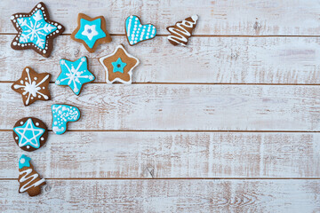 Frame made with different Christmas gingerbread cookies on rustic wooden background, top view. Space for text