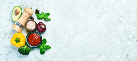 Bowl with tomato paste and ingredients for cooking, on a gray stone background. Ketchup. Top view. Free space for text.