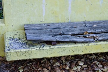 A ruined yellow concrete bench with a broken wooden seat (Pesaro, Italy, Europe) - 476278017