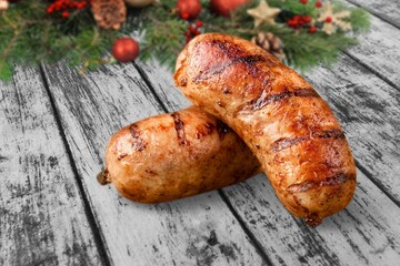 Christmas grilled sausages with spices on a stone background with Christmas trees and Christmas decorations, gifts