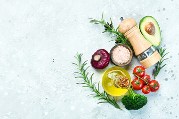 Food background. Vegetables, spices and pepper mill on a gray stone background. Top view. Free space for text.