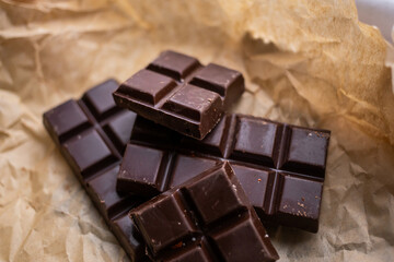 A bar of dark chocolate lies on the paper