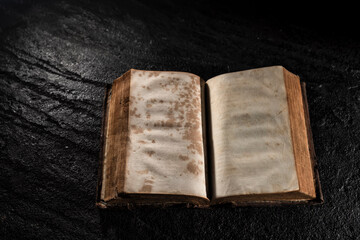 Open old book on dark background