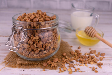 Homemade granola in a jar of honey and milk.