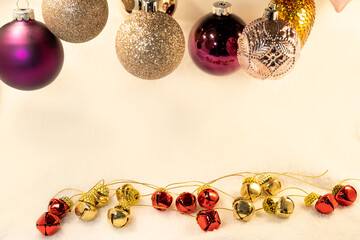 Holiday decorations with red and gold bells and colored spheres in a smooth background