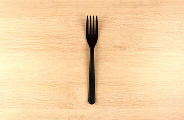 One plastic fork on wooden background