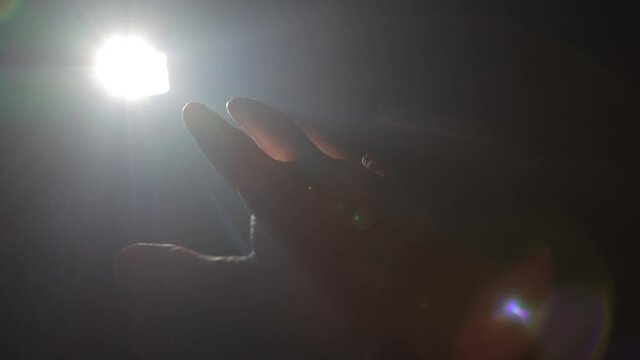Man holding his hand against ray of light