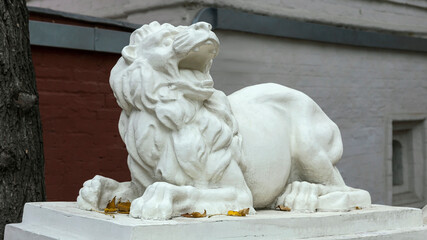 concrete sculpture of a formidable lion on a pedestal. The concept of strength, power