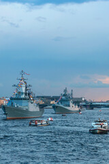 Modern warships. Tourists from pleasure ships and the embankment look at the warships on the Neva. Before the naval parade in St. Petersburg, Russia