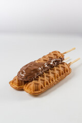 waffles sticks (three) with chocolate glazed and chocolate cookies. white background
