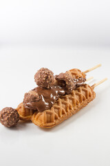waffles sticks (three) with chocolate glazed and chocolate cookies. white background
